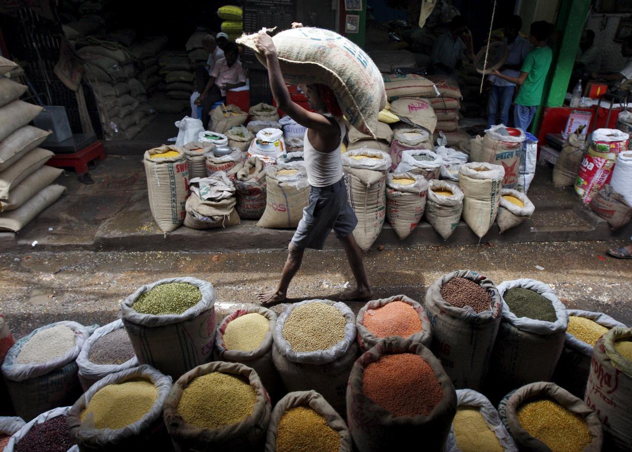 A labourer carries a sack filled with pulses at a wholesale pulses market in Kolkata